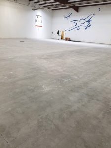Empty university hangar with rough concrete floor